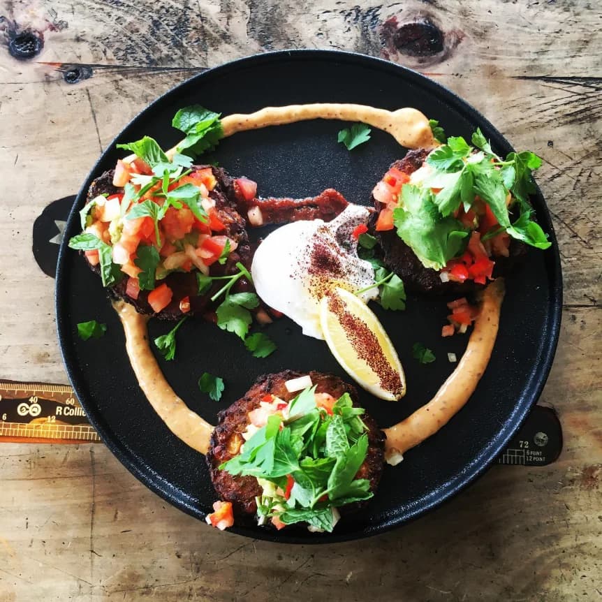 A plated café dish on a worn timber service table